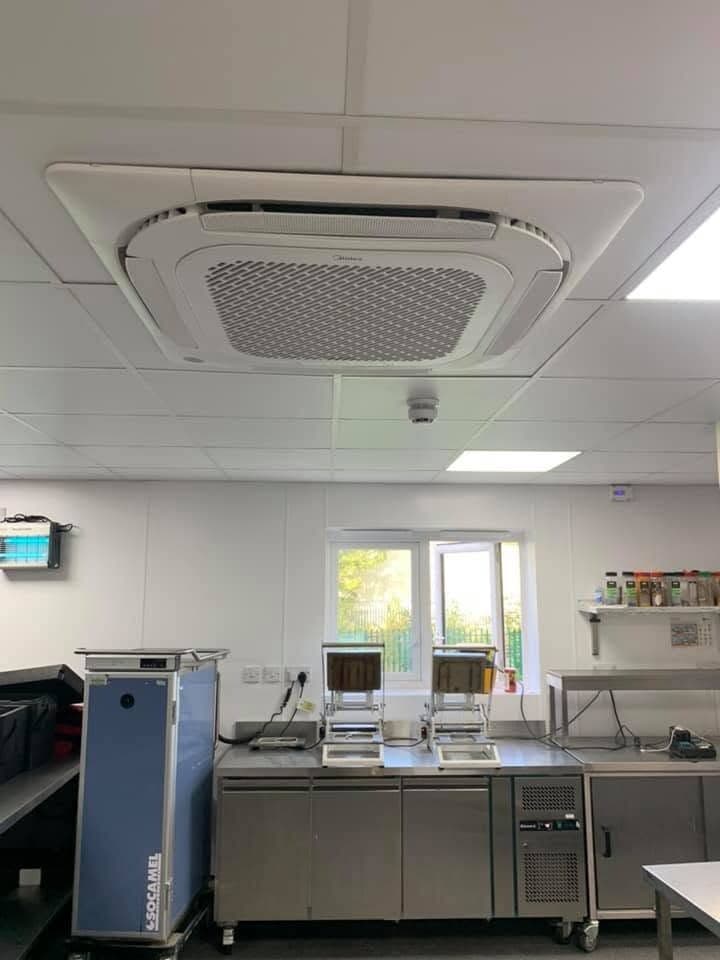 Stainless commercial kitchen with ceiling cassette air conditioning and panel lighting