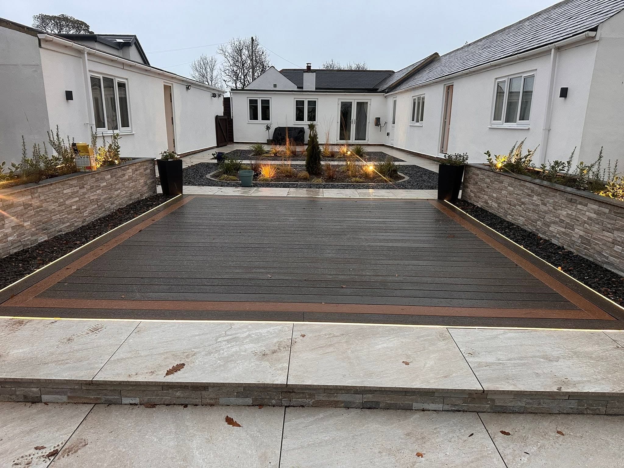 Courtyard garden with a large composite deck and LED strip lighting to both edges