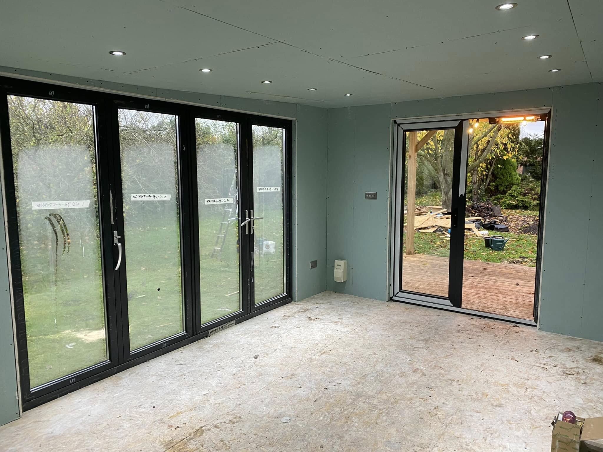 Garden room interior with recessed downlights and bifold doors onto the garden