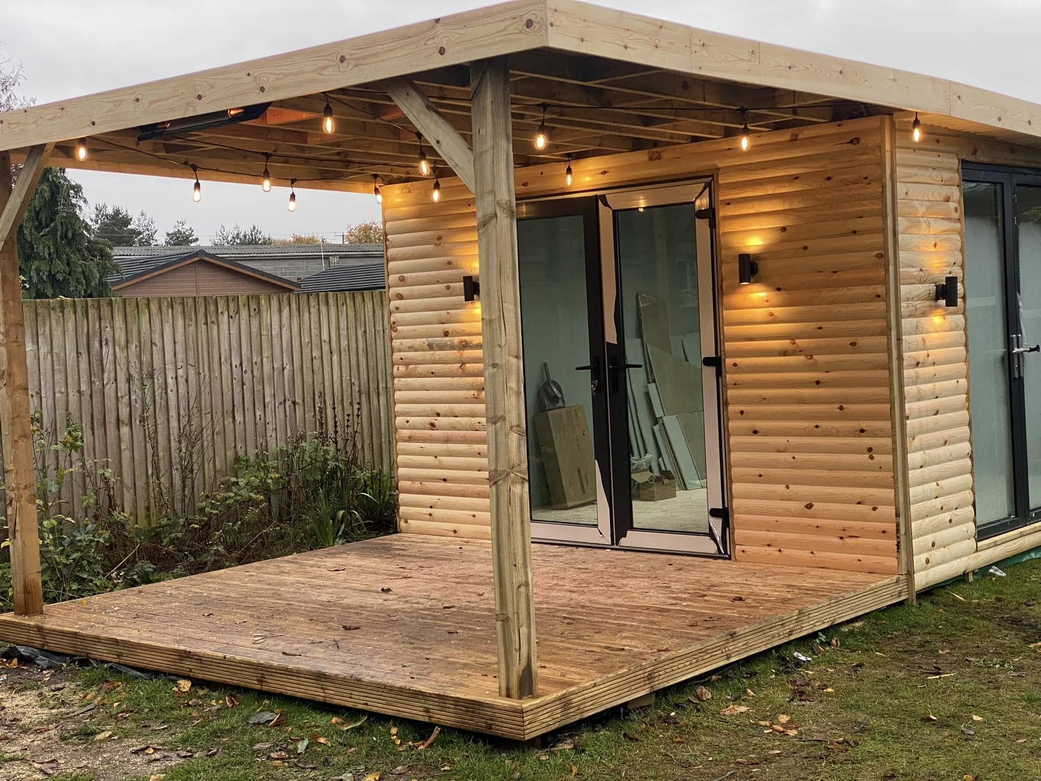 Garden room with an attached pergola strung with festoon lighting