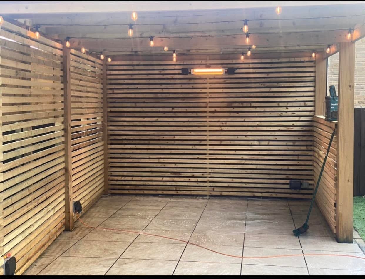 Covered pergola with festoon lighting and a wall-mounted infrared patio heater
