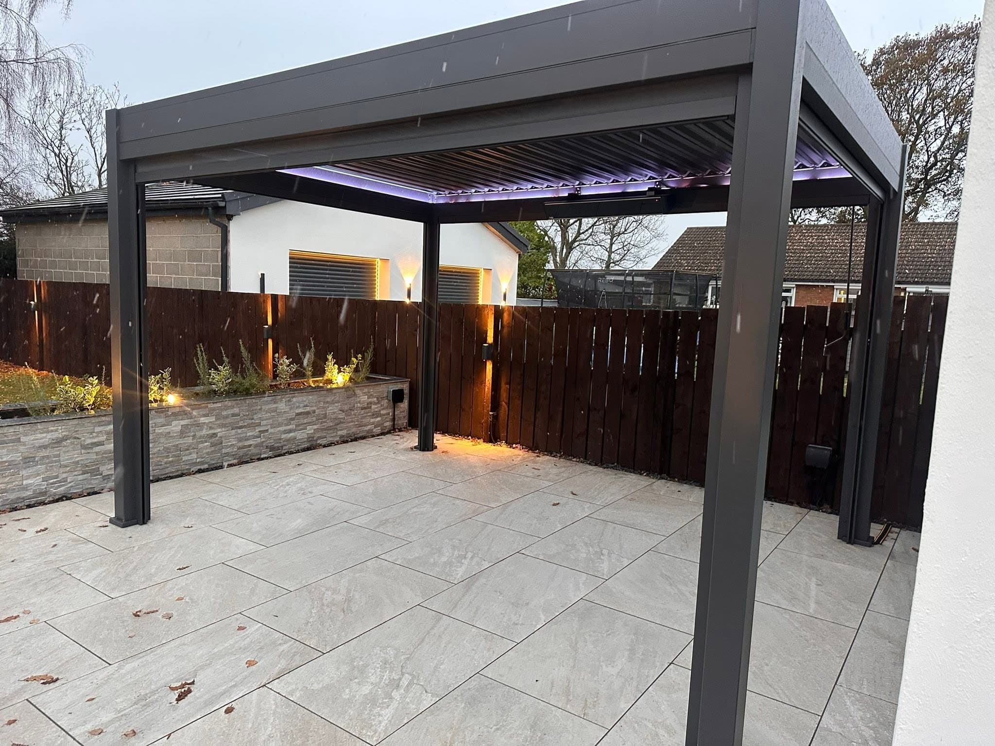 Aluminium louvred pergola with colour-changing LED perimeter lighting over a porcelain patio