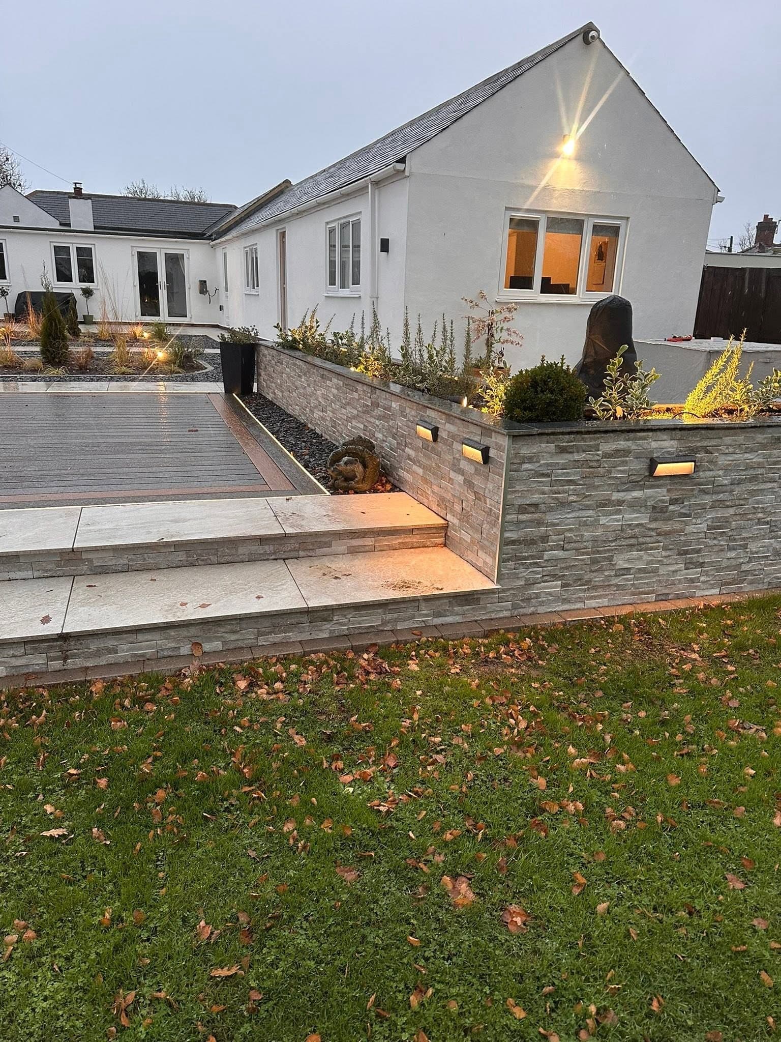 Patio steps with lit risers and wall lights to the side elevation